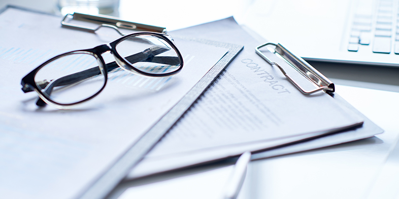 Close-up of clipboards with business papers and eyeglasses