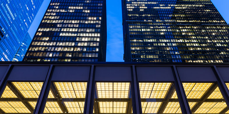 Looking up at dark skyscrapers.