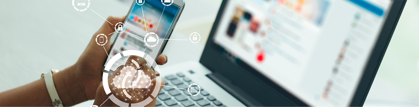 a smartphone held in front of a laptop with icons depicting cloud mased service synchronization