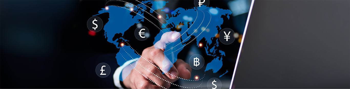 A conceptual photo depicting a hand pointing at a map surrounded by various currency symbols moving around