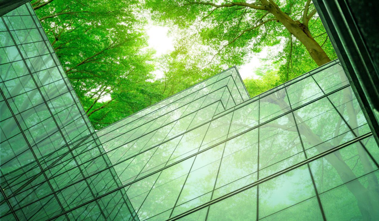 Eco-friendly building in the modern city. Sustainable glass office building with tree for reducing heat and carbon dioxide. Office building with green environment. Corporate building reduce CO2.