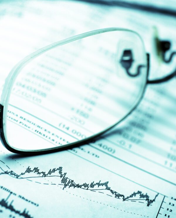 Stock chart on newspaper with a pair glasses on top.